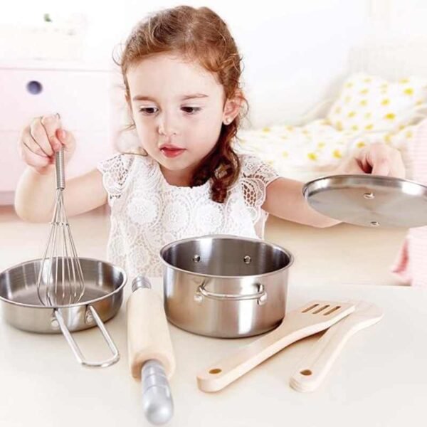 Sartenes de juguete con accesorios de madera. Niña jugando